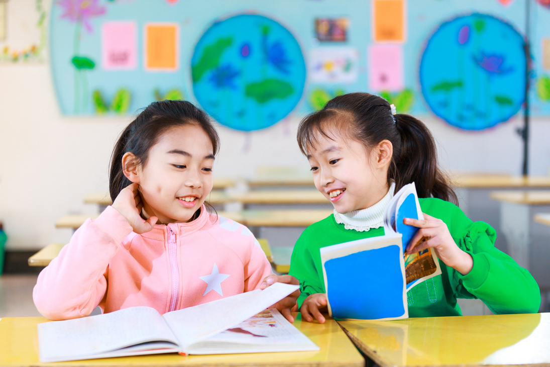 asian primary students read books in classroom